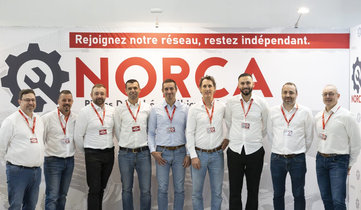 Equipe commercial au stand de la société NORCA au salon Solutrans 2025, espace d'accueil moderne pour les professionnels du transport.